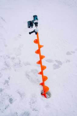 Orange Fishing Drill Stuck In Ice. High quality photo clipart