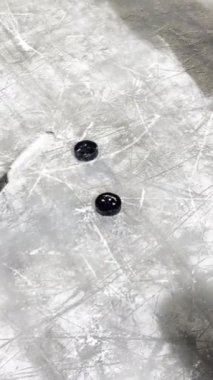 Buz pistinde iki disk ve bir hokey sopası. Yüksek kalite 4k görüntü