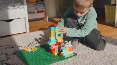 Güneşli bir günde çocuk odasında lego oynayan 4 yaşında bir çocuk. Yüksek kalite 4k görüntü