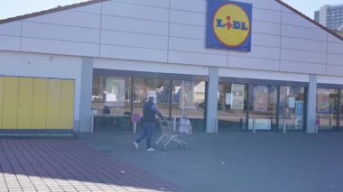 Avrupalı bir baba ve küçük oğlu LIDL 'e alışverişe gittiler. Çocuk rahat bir şekilde arabada oturuyor, etrafına bakıyor, babası onu itiyor, parlak bir günde dükkana girmeye hazırlanıyor. Yüksek