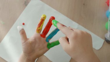 Boyayla boyanmış çocuklar, her biri farklı bir parmağın renginde, yukarıda 4-5 yaşındaki bir çocuğun avuç içi açık. Yüksek kalite fotoğraf