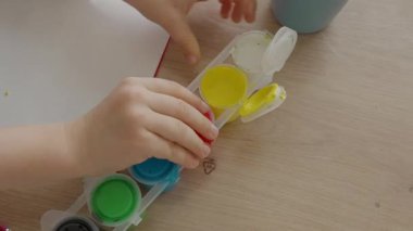 Erkekler boya kutularını açarlar, küçük çocuklar için boya kutularını açarlar, 4-5 yaşlarında bir çocuk açılır. Yüksek kalite 4k görüntü