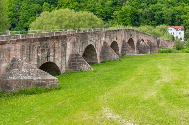 Tarihi taş kemer köprüsü Almanya 'yı doğu ve batıya bölen yemyeşil araziyi kapsar. Eski mühendislik yapısının kırsal cazibesi ve sağlam yapısı...