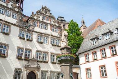 Karmaşık heykeller ve çiçeklerle süslenmiş birden fazla pencerenin yer aldığı tarihi bir binanın dekoratif cephesi berrak bir gökyüzü zeminine karşı mimari zarafeti yakalıyor. Almanya 'da kötü hissediyor. 