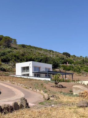 Modern beyaz saray manzaralı kırsal kesimlere yerleşmiş. Yumuşak bir tepeye çıkan dolambaçlı bir yol var. Yeşilliklerle çevrili yapı, çağdaş mimari tarzını yayıyor..