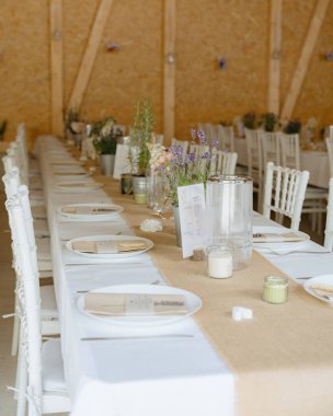 Lavanta rengi detaylar, kırsal dokular ve doğal tonlarla güzel bir düğün masası düzenlemesi. Davetiyeler, bloglar ve olay ilhamı için mükemmel.