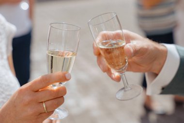 Kutlama için kadeh kaldıran iki kişi. Atmosfer neşeli bir olay olduğunu gösteriyor, muhtemelen bir düğün ya da özel bir olay, paylaşılan mutluluk ve bağın işaretlediği.