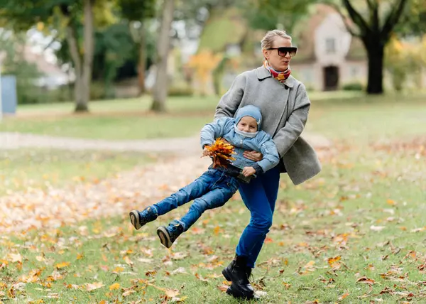 Sonbahar havasında, babası ve annesiyle birlikte bir sonbahar köyünde eski bir evin ve sonbahar ağaçlarının arka planında yürüyen bir çocuk, elinde bir buket akçaağaç yaprağı tutuyor. Yüksek kalite
