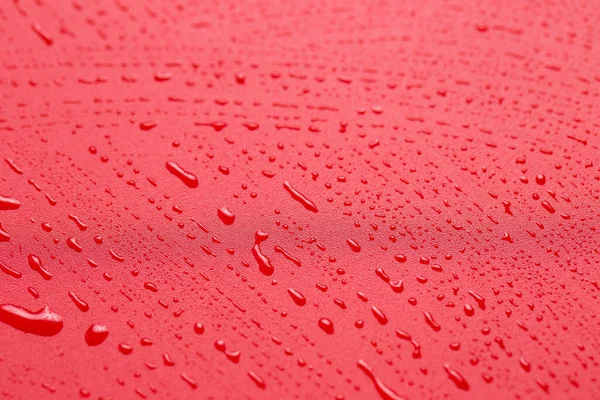 Red waterproof cloth covered with water drops.