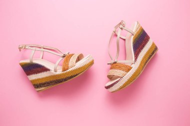 Pembe arka planda kadın sandaletleri..