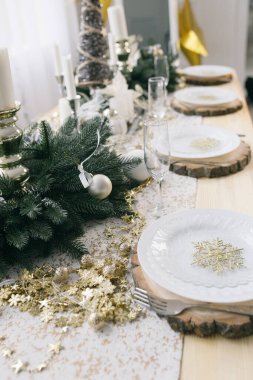 Yeni yıl masa dekoru. Mum, tabak ve süslemeli Noel masası..