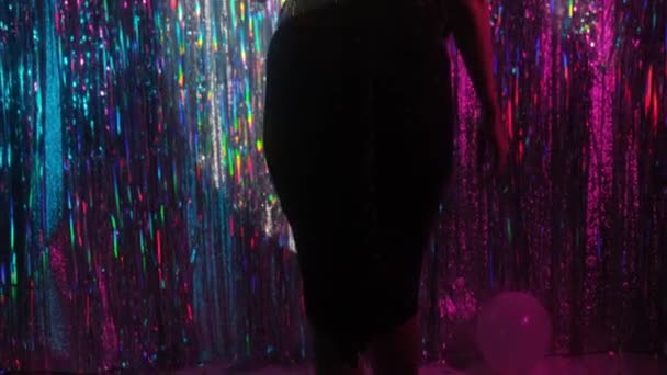 輝くマルチカラーを背景に ガラスを手にしたエレガントなお祝いのドレスの女の子 — ストック動画