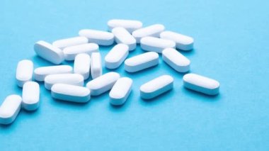 Mavi arka planda beyaz haplar. Yakın plan..