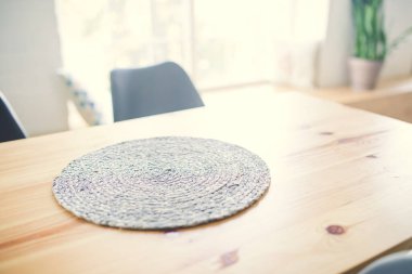 Parlak beyaz bir odada pencerenin arka planına karşı ahşap masa.