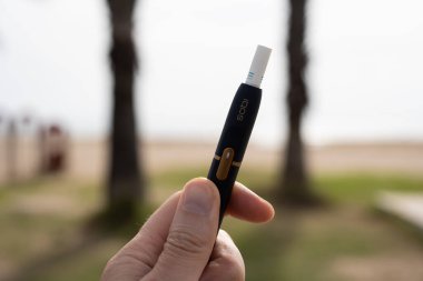 Tarragona, İspanya - 29 Ekim 2022: Phillip Morris Uluslararası Marlboro IQOS, bir erkeğin elindeki elektronik sigara.