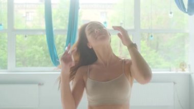 Portrait of a beautiful girl sports trainer in the yoga room.