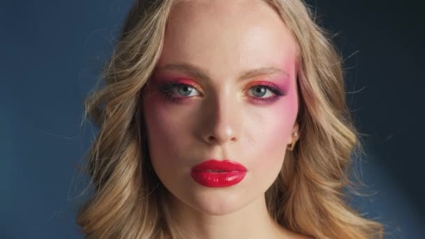 Parlak Makyajlı Kırmızı Dudaklı Güzel Bir Model Mavi Arka Planda — Stok video