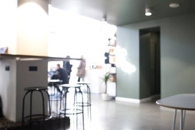 İnsanlarla dolu bir kafenin bulanık fotoğrafı. İçi beyaz olan bir kafeterya..