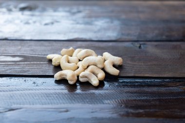 Ahşap bir masanın üzerinde çiğ kaju fıstığı..