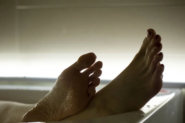 stock image Feet in the bathroom closeup. Steamed female heels. Manicure.