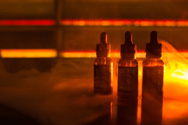 泡沫液体瓶子在黑暗的背景与烟雾和橙色的光 雾腾腾的背景 — 图库照片