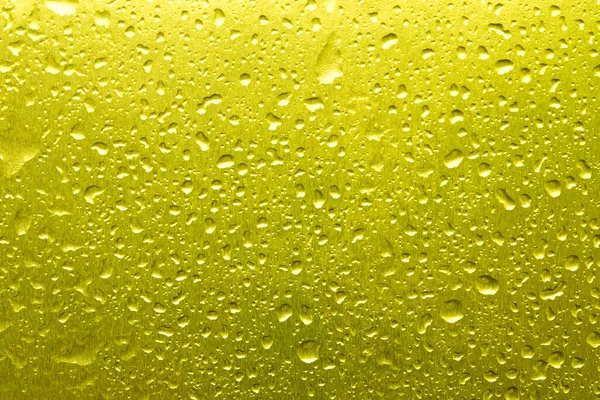 黄色の背景に水が落ちるクローズアップ — ストック写真
