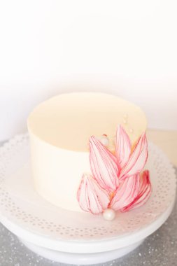 Açık arkaplanda güzel çiçekler olan beyaz pasta..