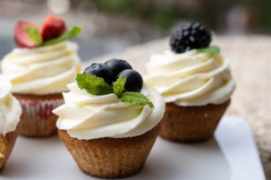 Beyaz bir kapta farklı meyveli kekler..