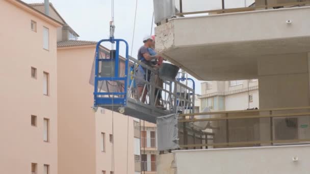 西班牙塔拉戈纳 2023年6月2日 建筑工人与一名冲浪者一起在房子的立面电梯上工作 — 图库视频影像