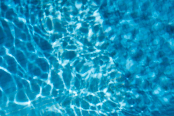 夏の晴れた日に青いスイミングプールでの水の質感の写真 — ストック写真