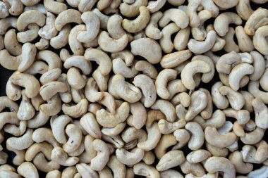 Ahşap bir masanın üzerinde çiğ kaju fıstığı..