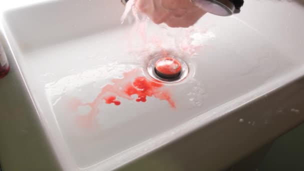 男は手を負傷し 近くに流れる水の下で血を洗い流す — ストック動画
