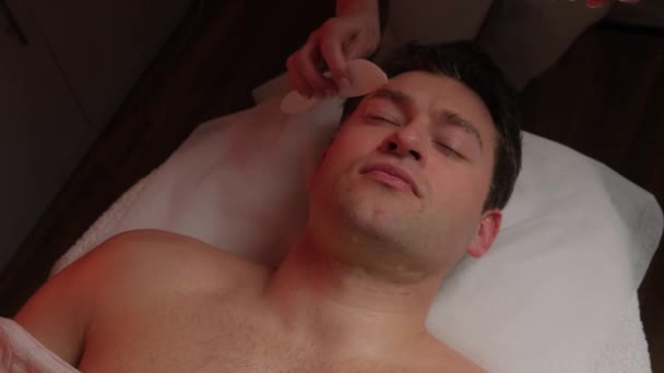 Esthéticienne Appliquant Gommage Sur Visage Des Jeunes Hommes Dans Salon — Video