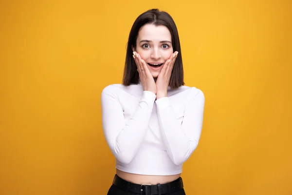 stock image Portrait of a surprised girl on a yellow background.