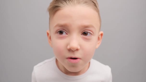 Malý Chlapec Bílém Tričku Zamyšleně Podívá Kamery Pak Šťastně Usměje — Stock video