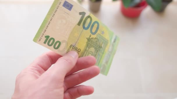 一个人手里拿着一张100欧元的钞票 — 图库视频影像