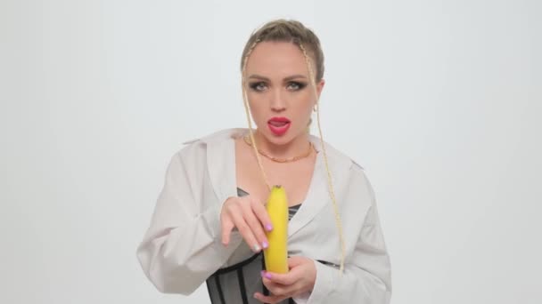 Hermosa Rubia Apasionadamente Abre Plátano Estudio Sobre Fondo Blanco — Vídeo de stock