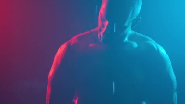 Muž Kulturista Ukazuje Svaly Pažích Neonovém Světle Kouři — Stock video