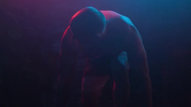 Erkek Vücut Geliştirici Çömelmiş Başlamaya Hazırlanıyor Kameraya Bakıyor Neon Işıkta — Stok video