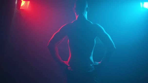 Muž Kulturista Ukazuje Svaly Pažích Neonovém Světle Kouři — Stock video