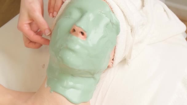 Junge Frau Mit Gesicht Bedeckt Mit Grüner Feuchtigkeitsspendender Alginatmaske Schönheitssalon — Stockvideo