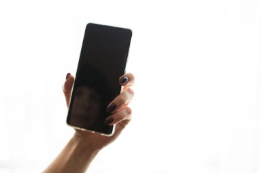 İzole edilmiş beyaz arkaplanda siyah ekranlı cep telefonu.