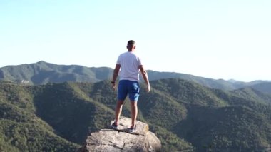 Yüksek kayalıkların tepesindeki turist kollarını açtı. Özgürlük ve başarı hissi..