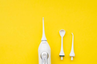 Farklı hortumlarla sarı arka planda ağız spreyi. Yukarıdan görüntüle.