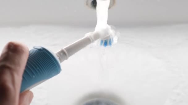 浴室のクローズアップのシンクの上の現代電気歯ブラシ — ストック動画