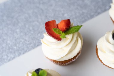 Beyaz bir kapta farklı meyveli kekler..