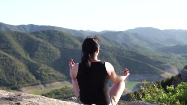 女性は早い夏の晴れた朝に山頂にたくさん座っています — ストック動画