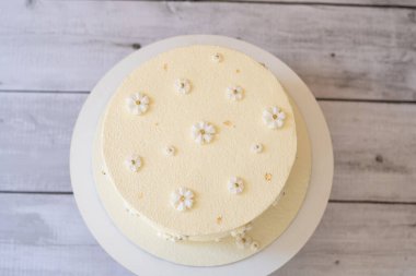 Gri ahşap masa manzaralı beyaz Raffaello pastası..