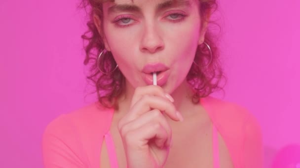 Гламурная Красивая Молодая Женщина Модель Розовом Фоне Ест Шоколадный Леденец — стоковое видео