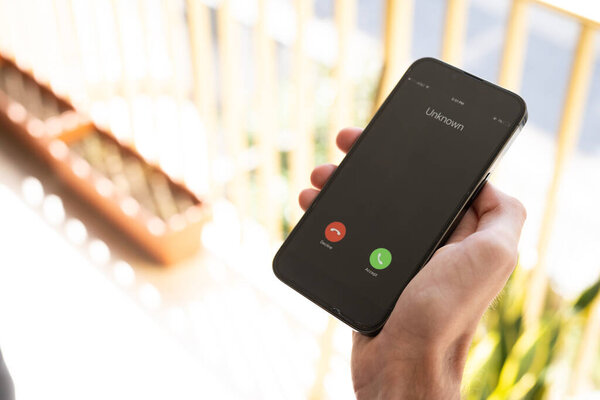 Мошенничество или мошеннические схемы. Крупный план мужчины, держащего телефон с неожиданным входящим звонком от неизвестного